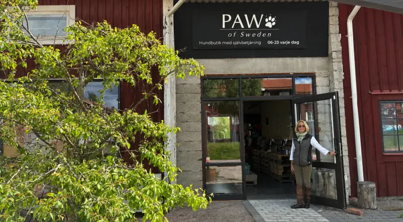 Petronella Lindmark i entrén till PAW of Sweden på Stationsgatan i Leksand. Skylten anger hundbutik med självbetjäning, öppet 06–23 varje dag.